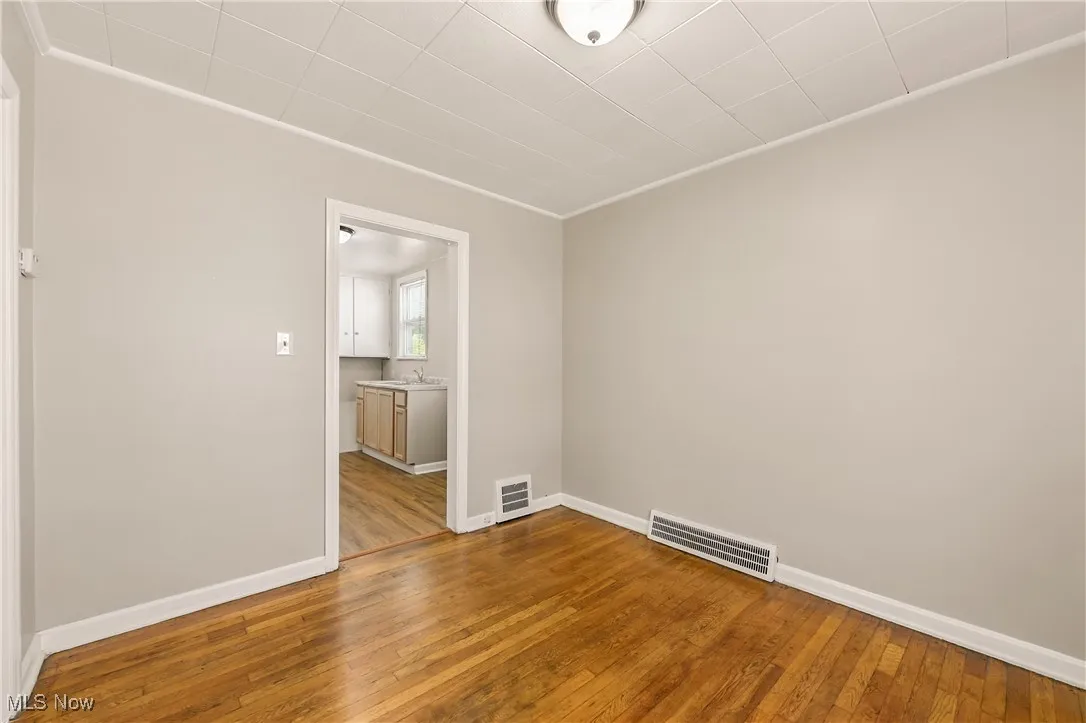 Empty room featuring hardwood / wood-style floors and crown molding