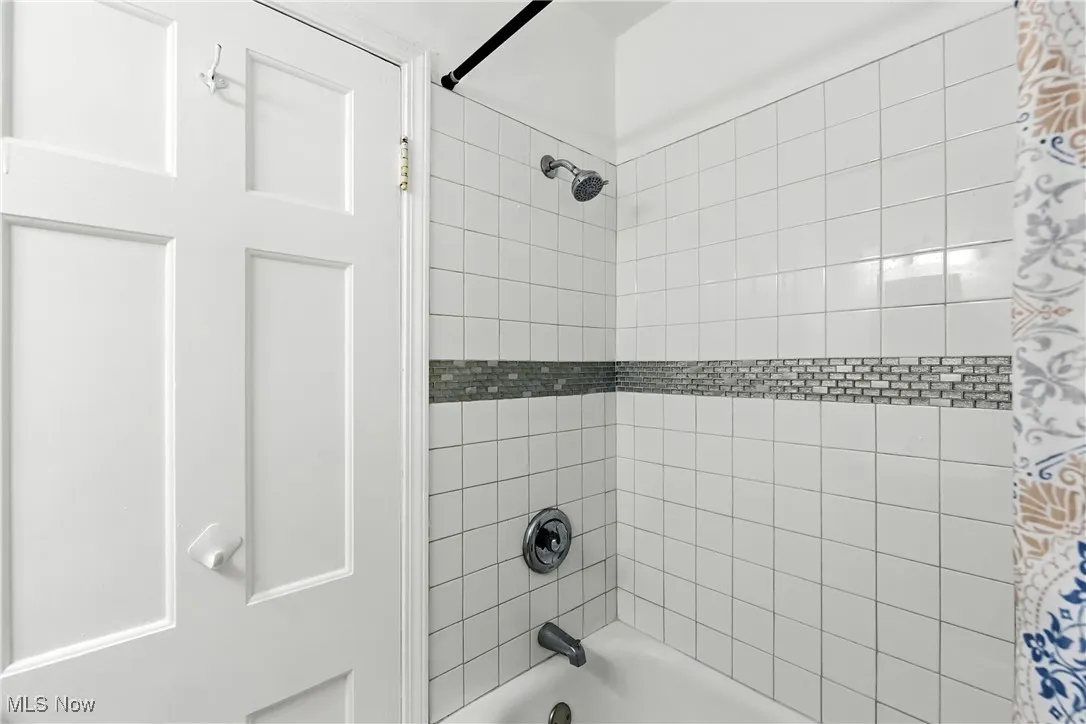 Bathroom featuring shower / bathtub combination with curtain