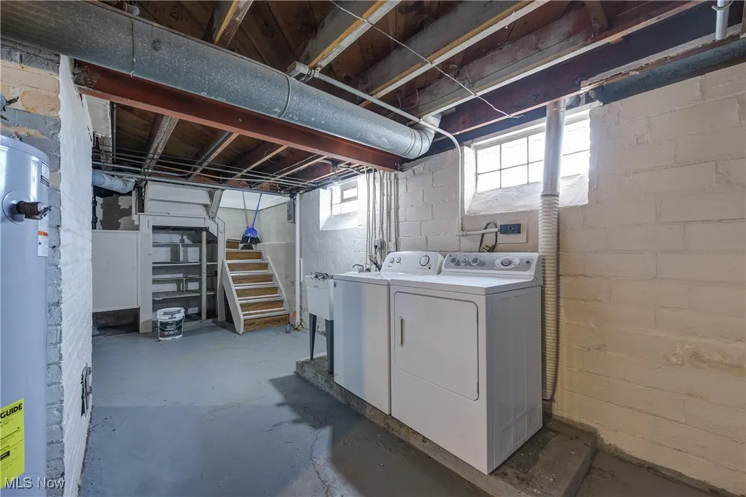 Below grade area with separate washer and dryer, water heater, and stairs