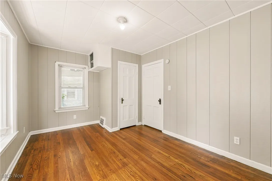 Spare room with dark wood-style flooring and a decorative wall