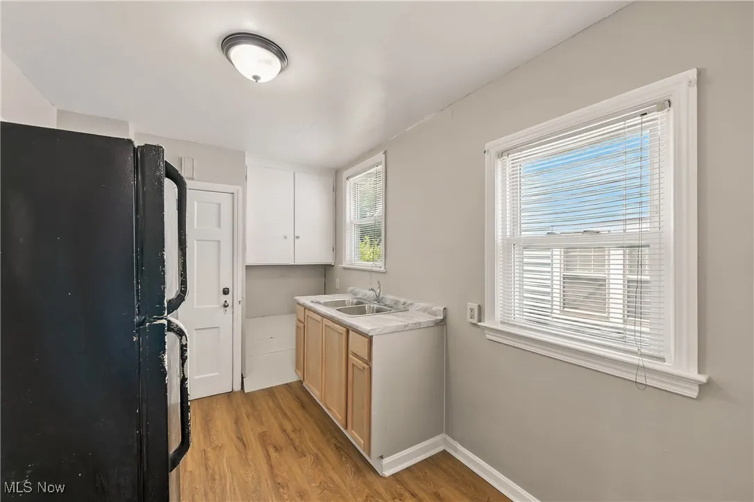 Kitchen with freestanding refrigerator, light wood finished floors, and light countertops