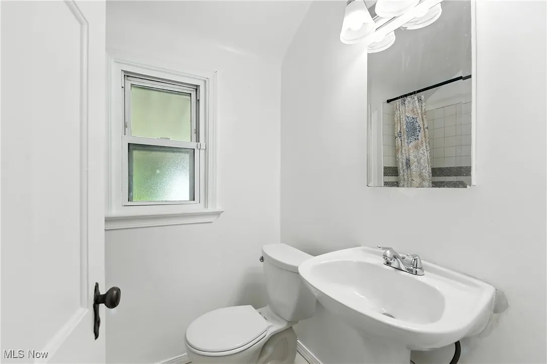 Bathroom with toilet and a shower with shower curtain
