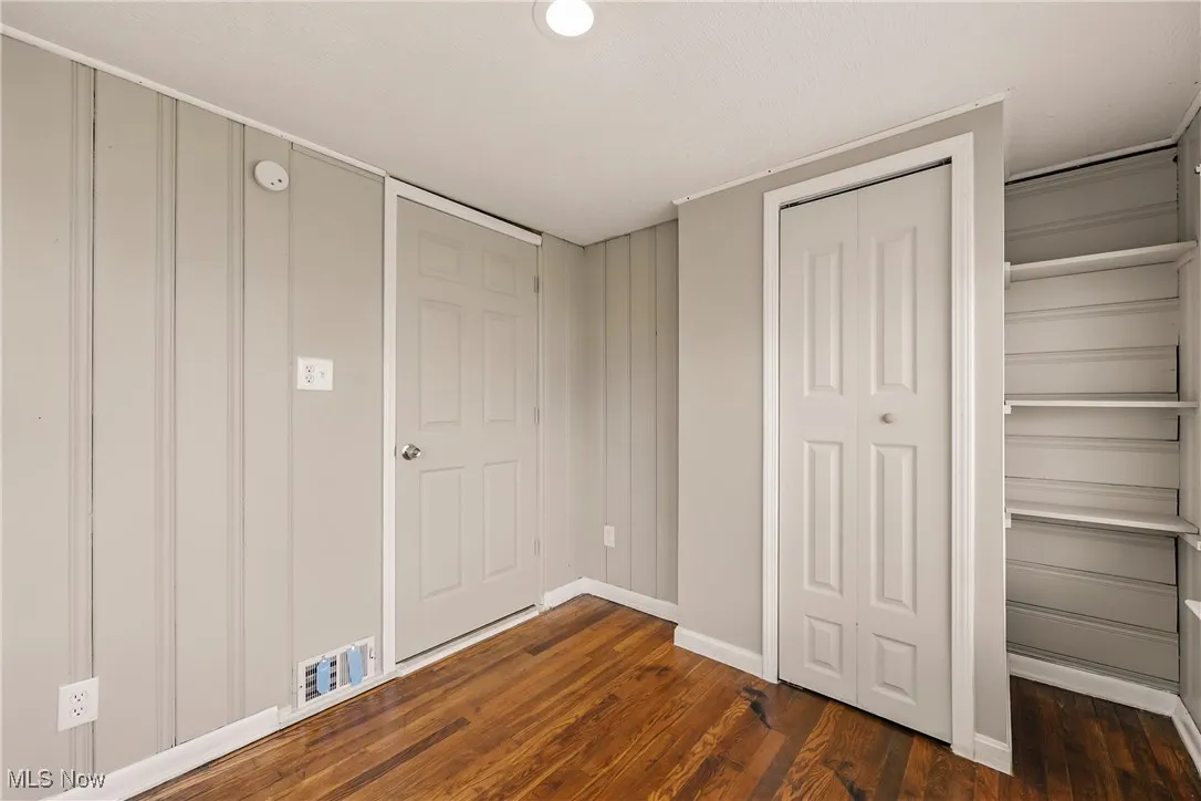 Unfurnished bedroom with dark wood finished floors and a closet