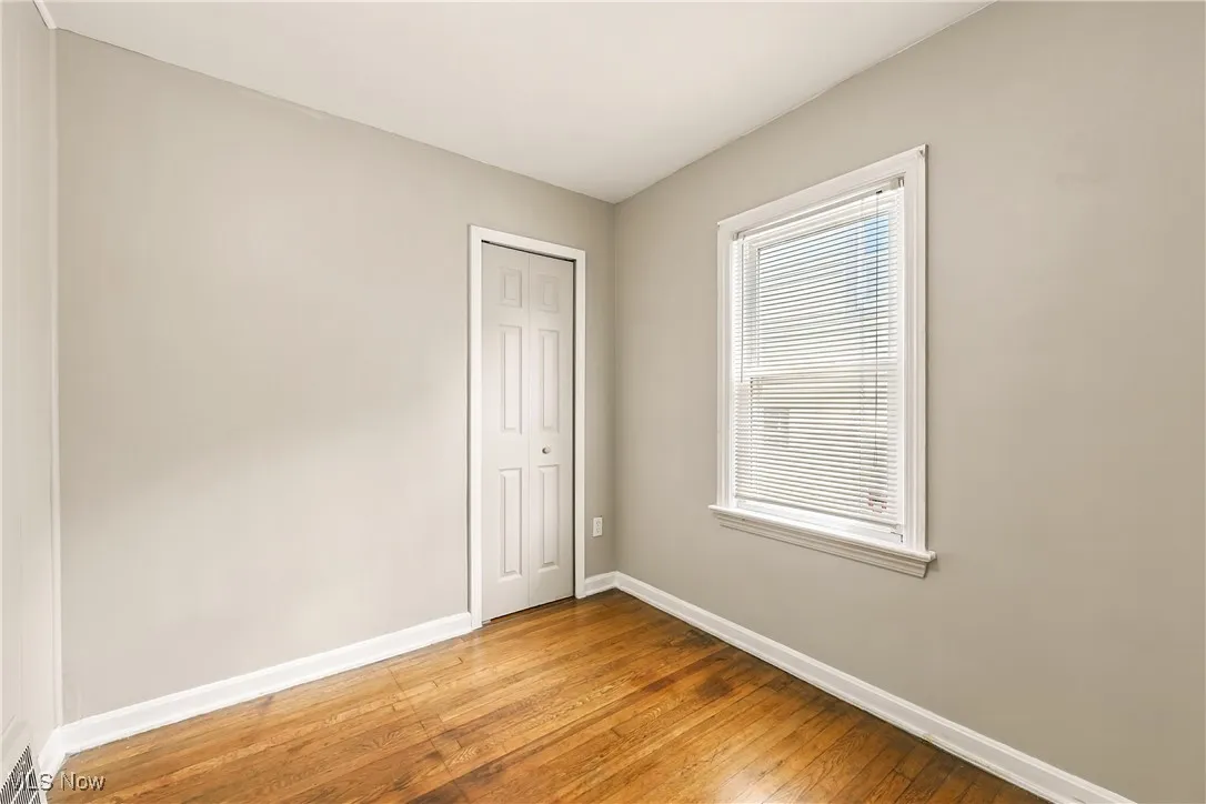 Unfurnished room with baseboards and hardwood / wood-style floors
