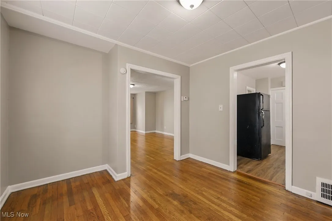 Unfurnished room featuring hardwood / wood-style floors and ornamental molding