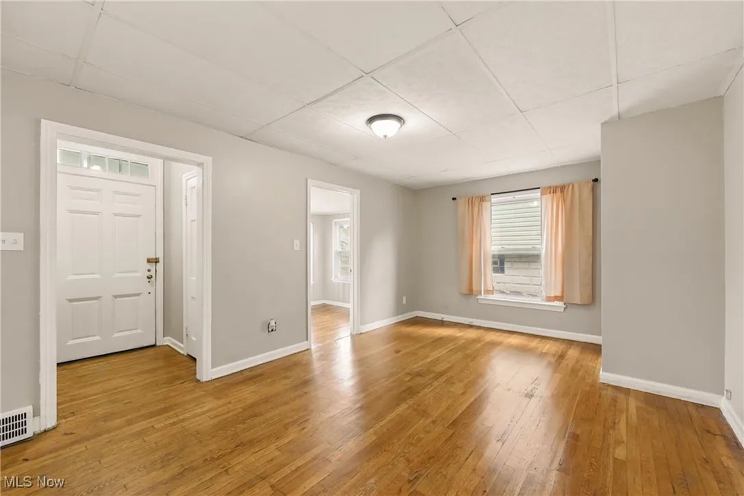 Entrance foyer with a paneled ceiling and hardwood / wood-style flooring