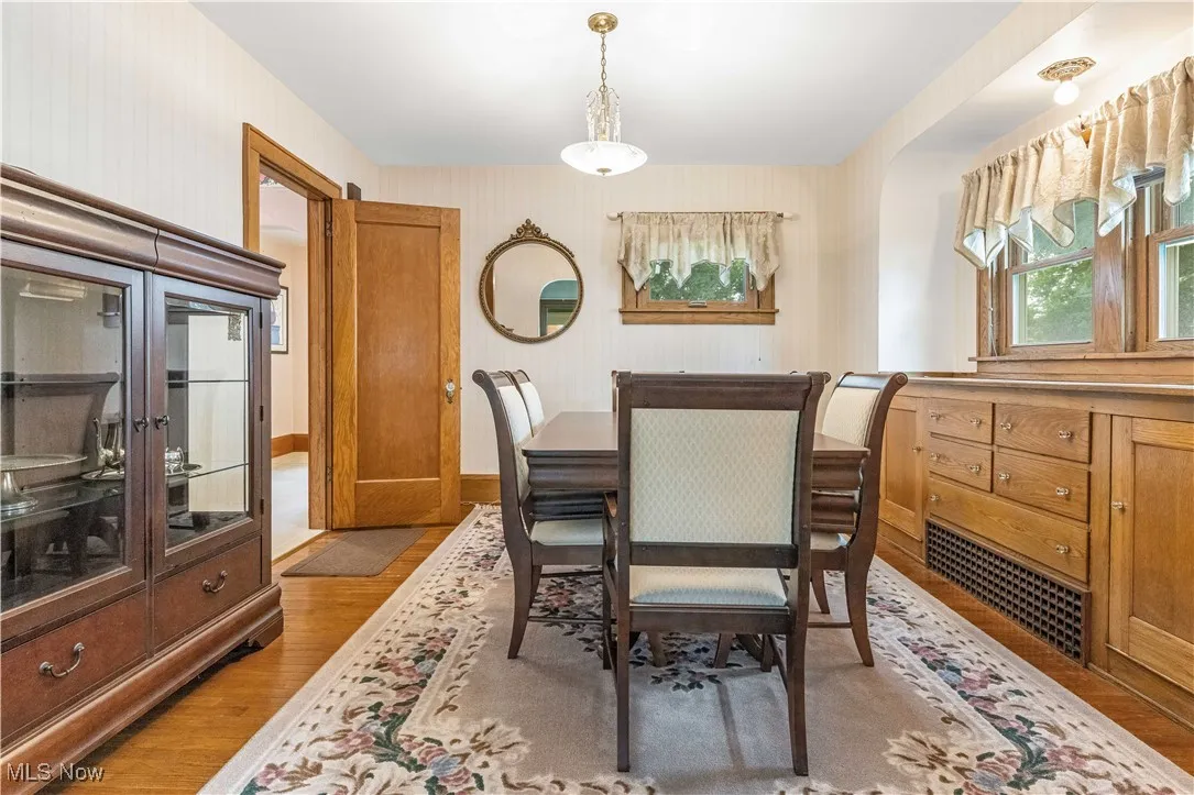 Dining space featuring wood finished floors and arched walkways
