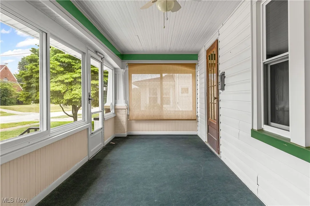 Unfurnished sunroom with ceiling fan and healthy amount of natural light