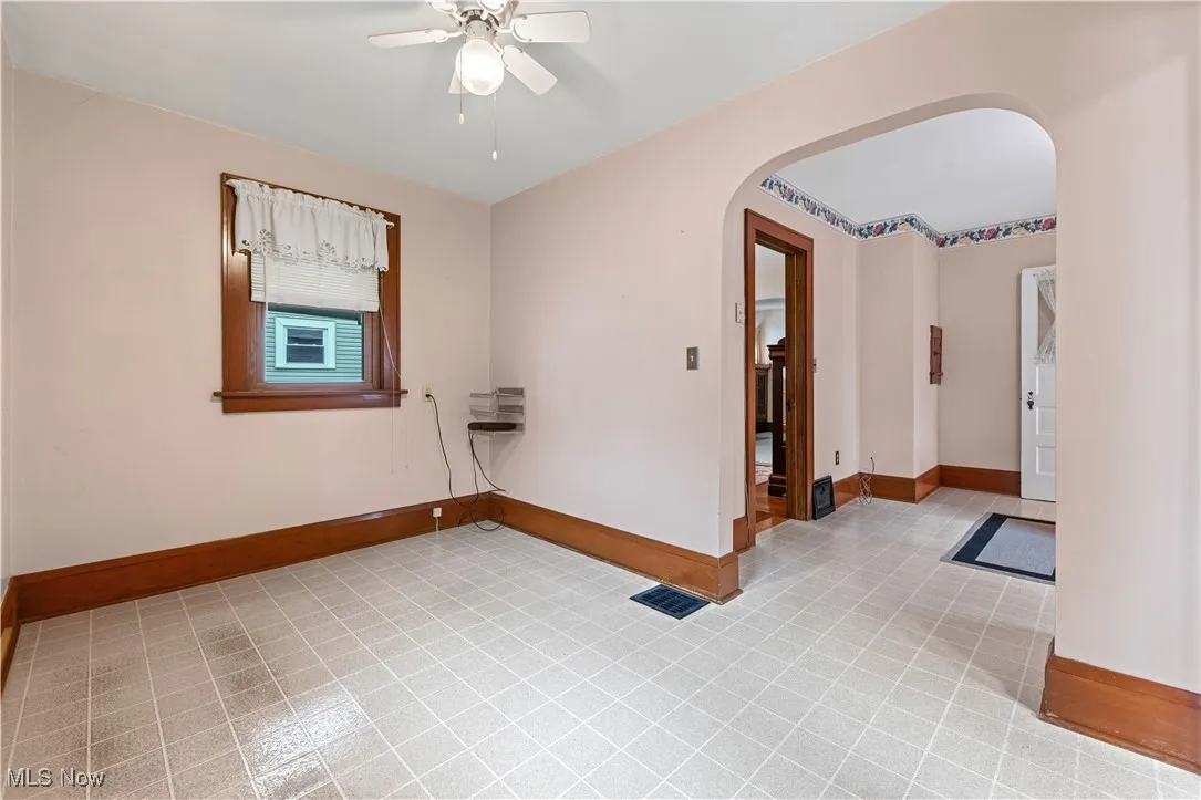 Empty room with arched walkways and a ceiling fan