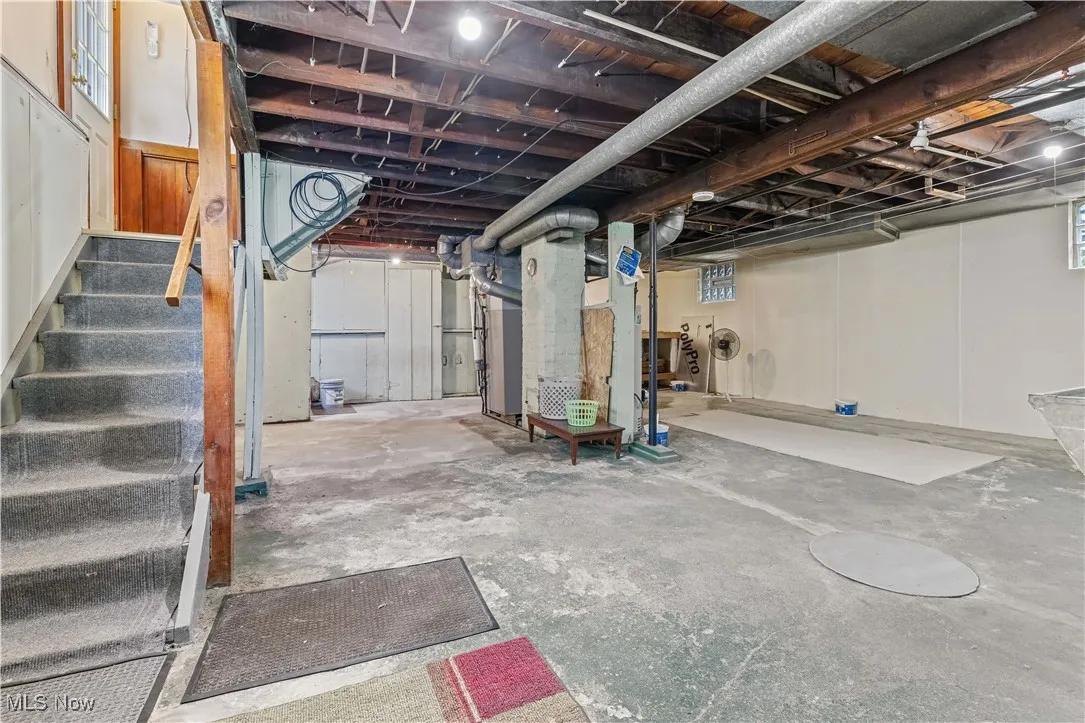 Unfinished below grade area featuring stairway