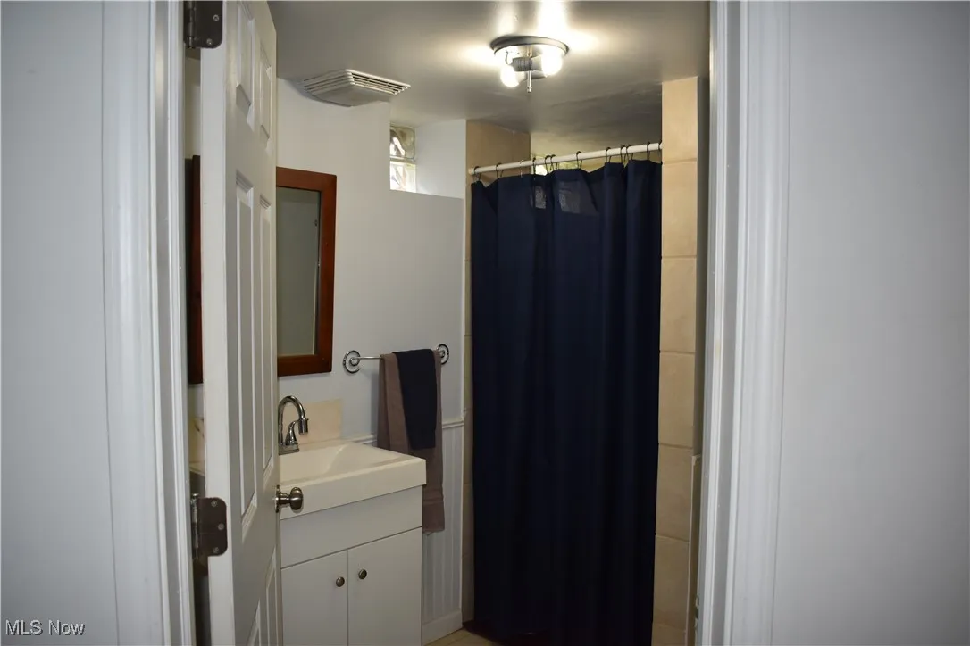 Bathroom with vanity and curtained shower