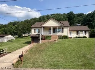 Bungalow featuring a porch and a front lawn
