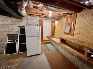 Unfinished below grade area featuring freestanding refrigerator