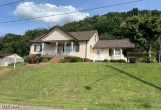 View of front of home featuring covered porch and a front lawn