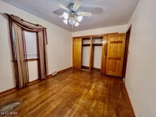Unfurnished bedroom with wood finished floors and ceiling fan