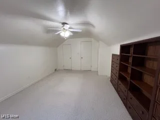 Bonus room featuring vaulted ceiling, a ceiling fan, and light colored carpet