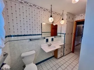 Bathroom featuring tile patterned flooring and tile walls