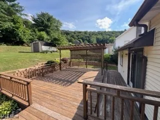 Deck featuring a lawn and a shed