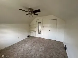Bonus room with lofted ceiling, a ceiling fan, and carpet floors