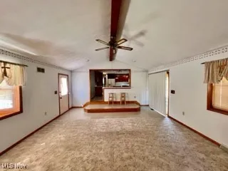 Unfurnished living room with baseboards and ceiling fan