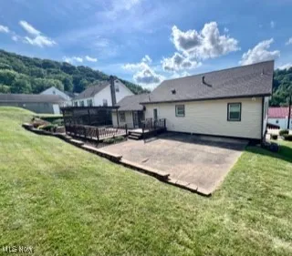 Back of house with a patio, a yard, and a wooden deck
