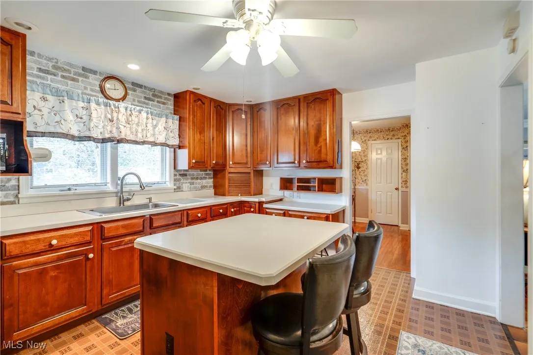 Kitchen featuring light countertops, a ceiling fan, a center island, light floors, and recessed lighting