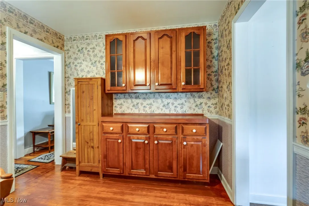 Bar area featuring wallpapered walls and wood finished floors