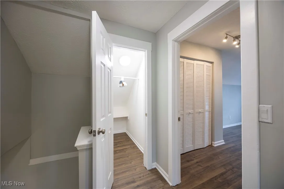 Corridor with wood finished floors and baseboards