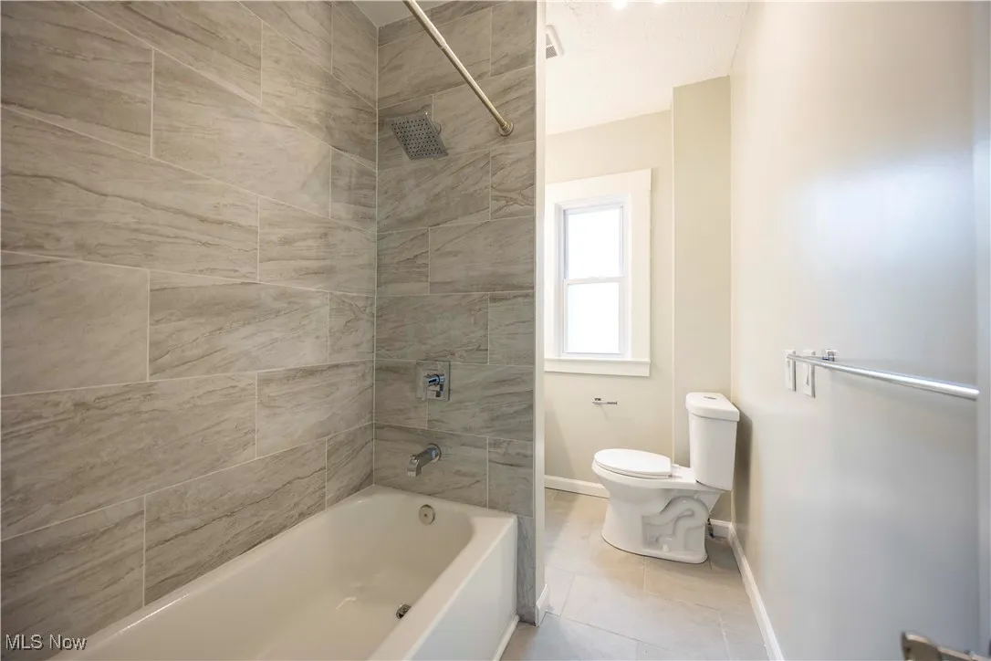 Full bathroom with  shower combination and tile patterned flooring