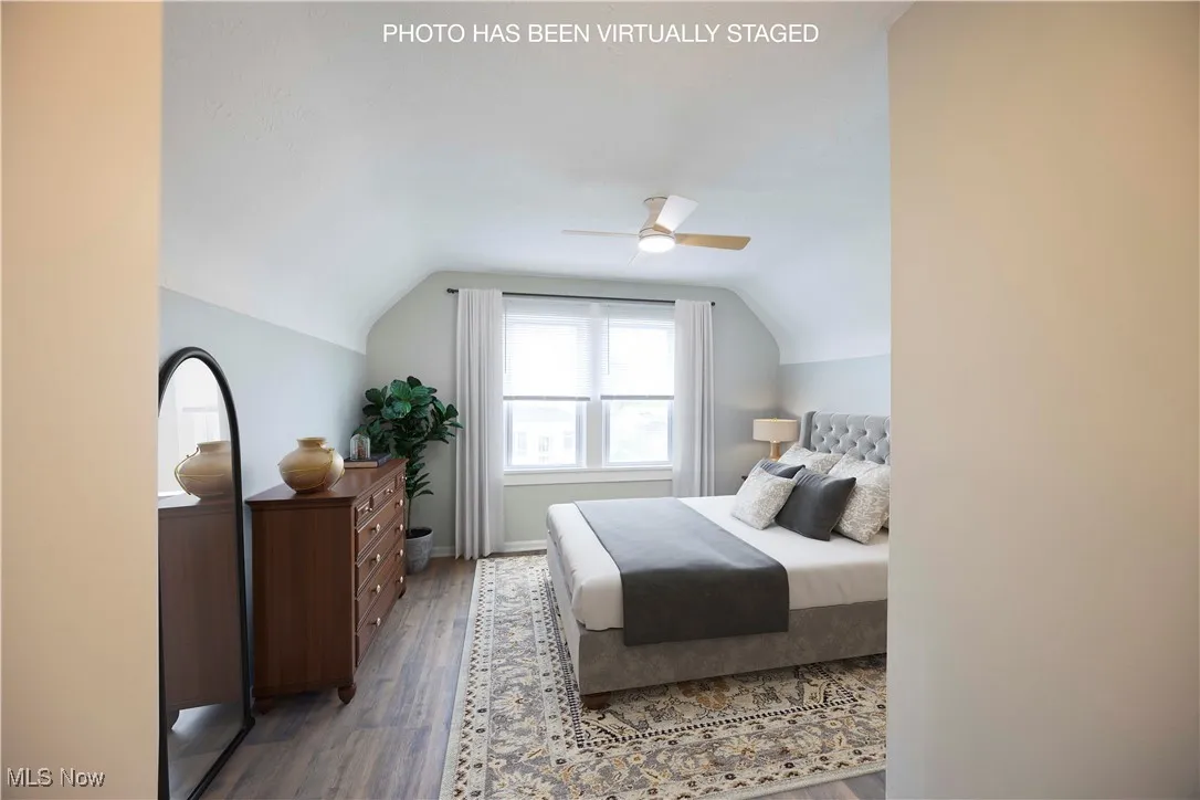 Bedroom featuring vaulted ceiling, wood finished floors, and ceiling fan