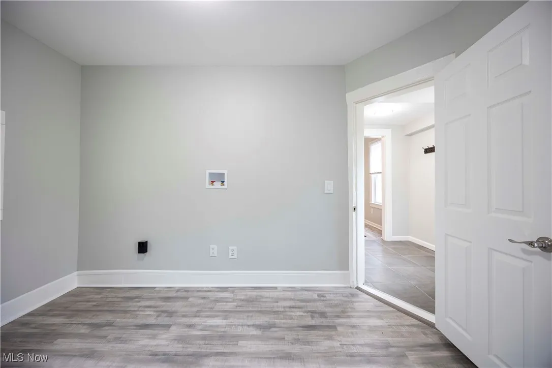 Unfurnished room with wood finished floors and baseboards