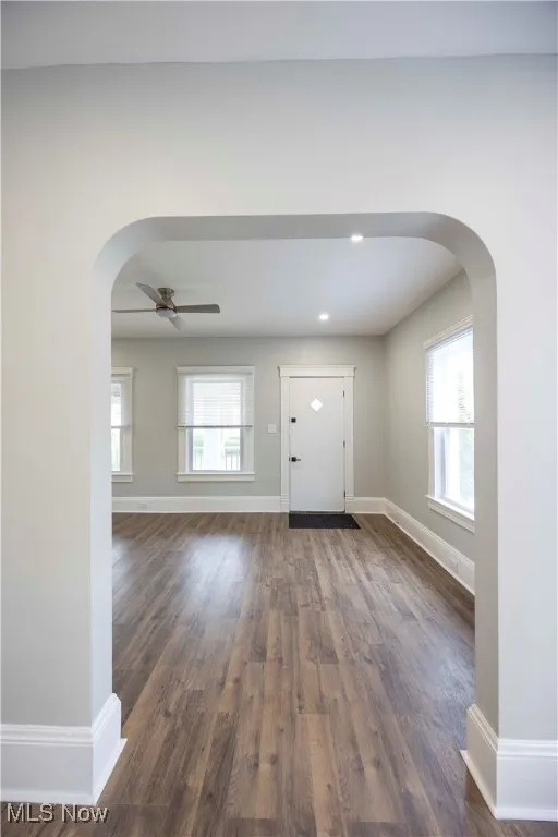 Entrance foyer featuring arched walkways, ceiling fan, dark wood-type flooring, and recessed lighting