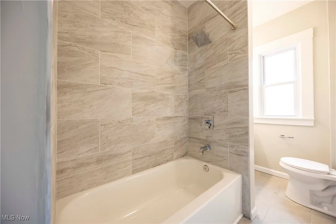 Full bathroom with toilet and shower / washtub combination