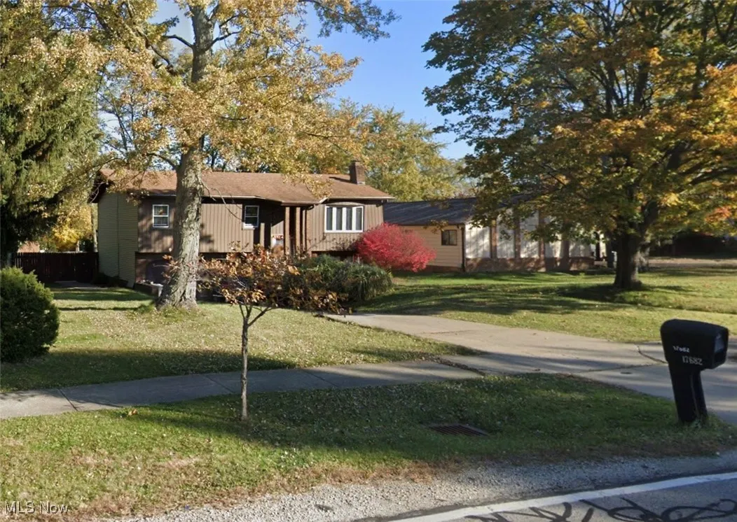 Single story home with a chimney and a front yard