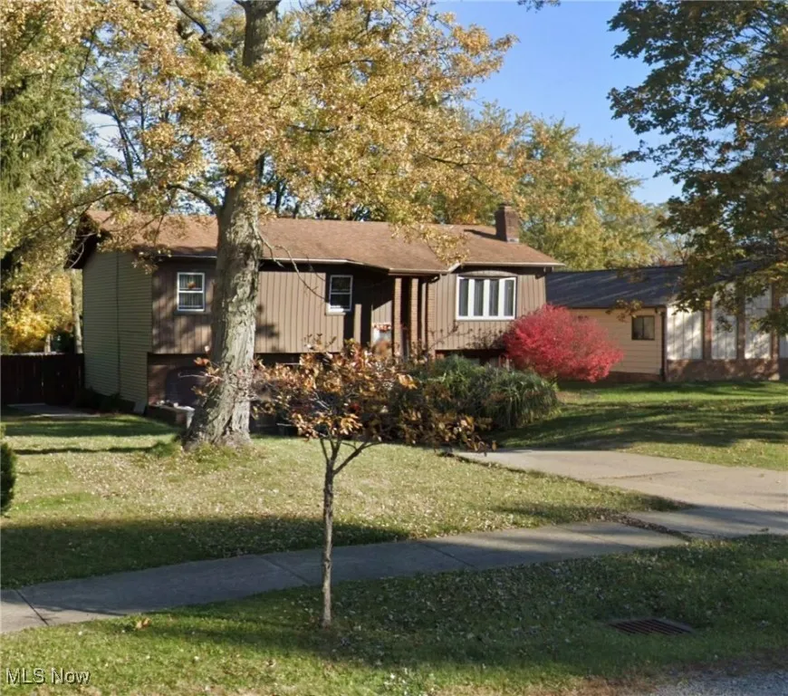 Ranch-style home with a front lawn and a chimney