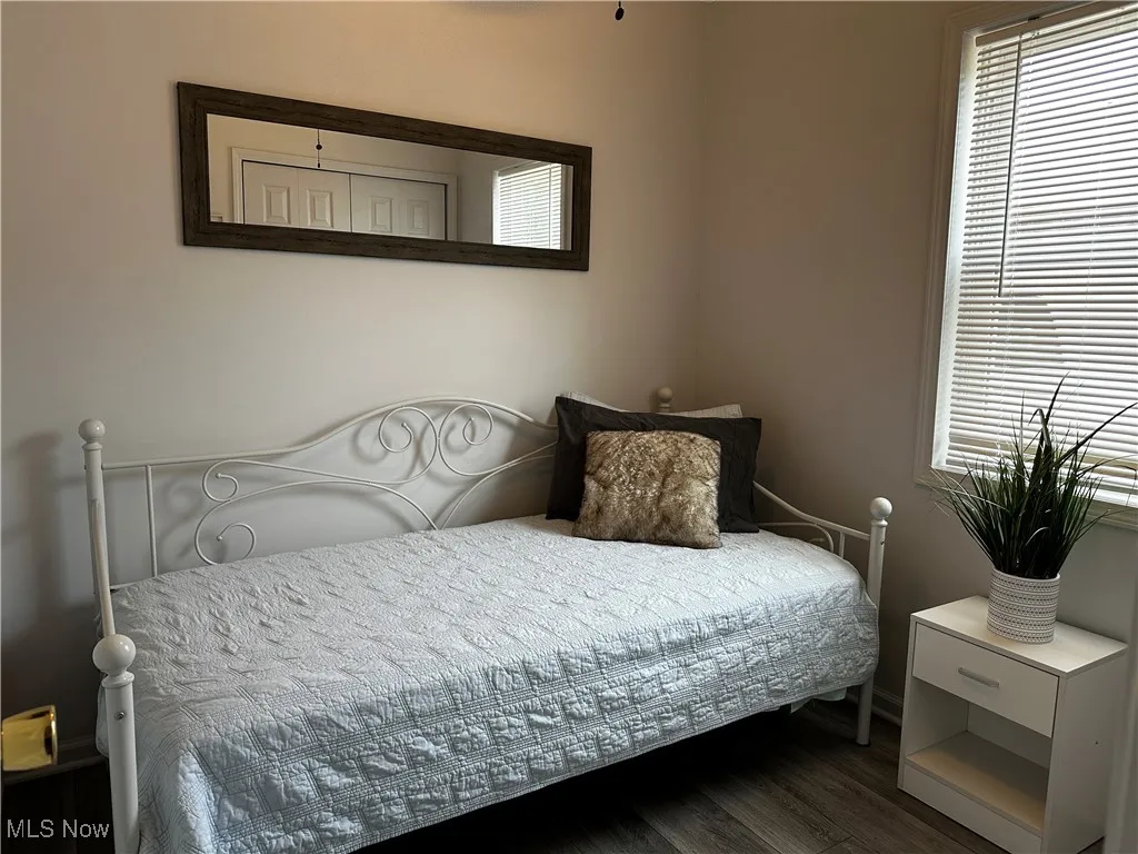 Bedroom featuring dark wood finished floors and baseboards