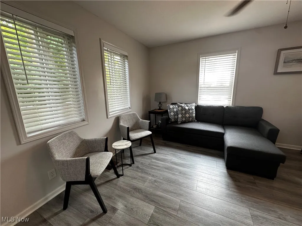 Living area with wood finished floors and ceiling fan