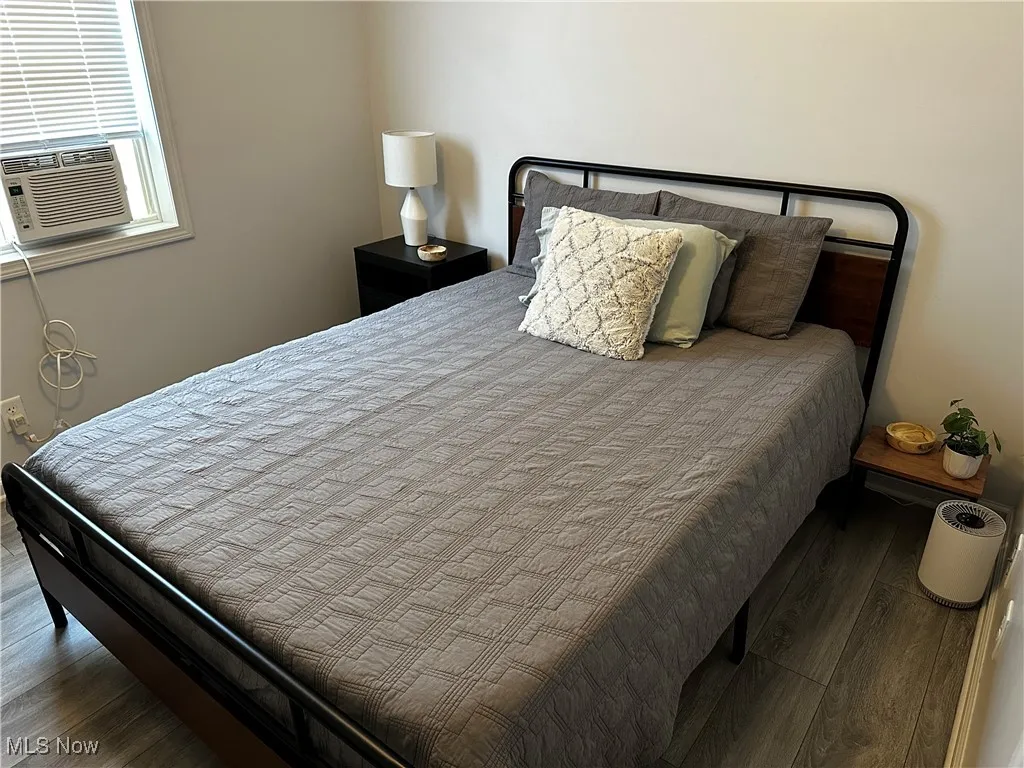 Bedroom featuring wood finished floors and cooling unit