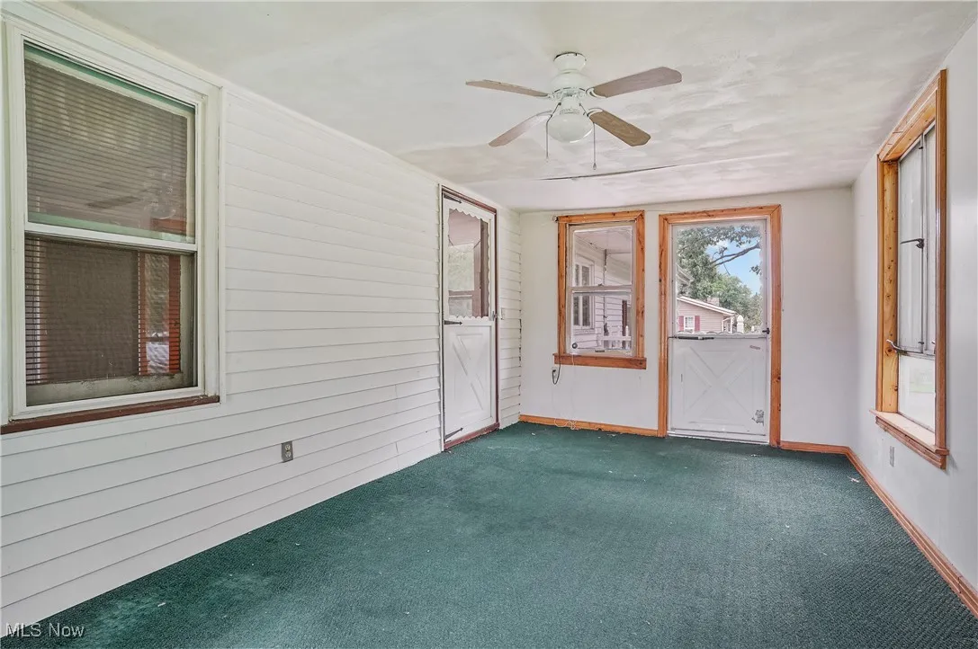 Unfurnished sunroom with ceiling fan