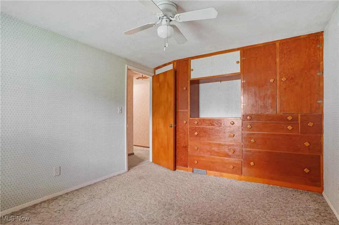 Unfurnished bedroom featuring carpet flooring and ceiling fan