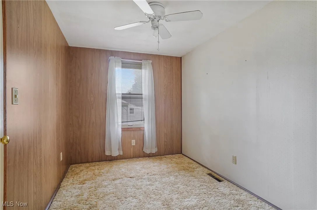 Empty room with carpet floors and a ceiling fan