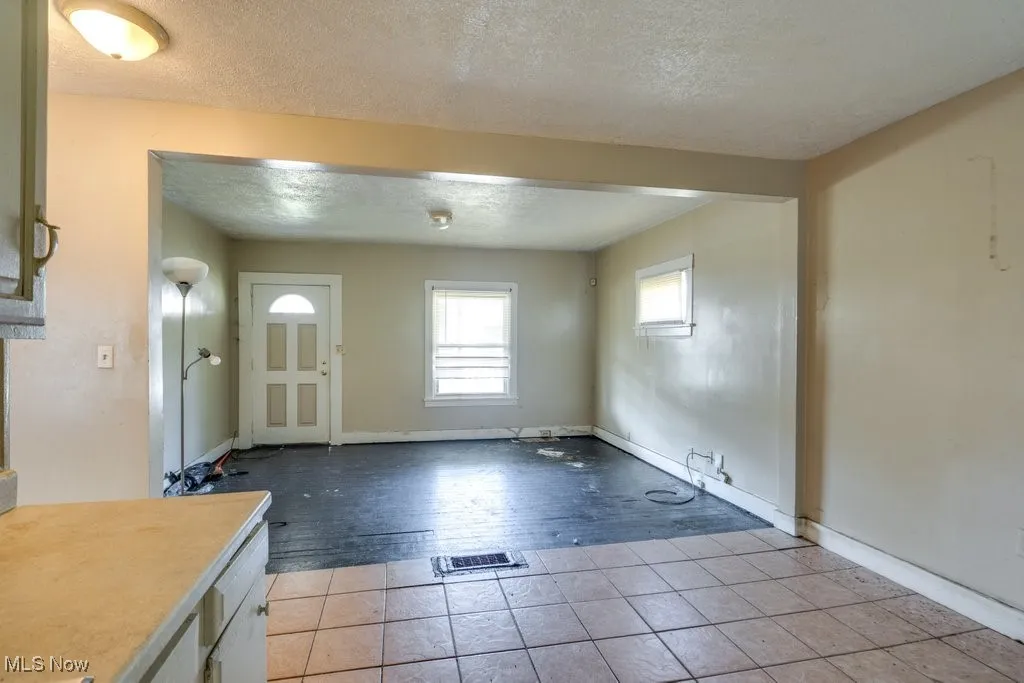Entryway with a textured ceiling and light tile patterned floors