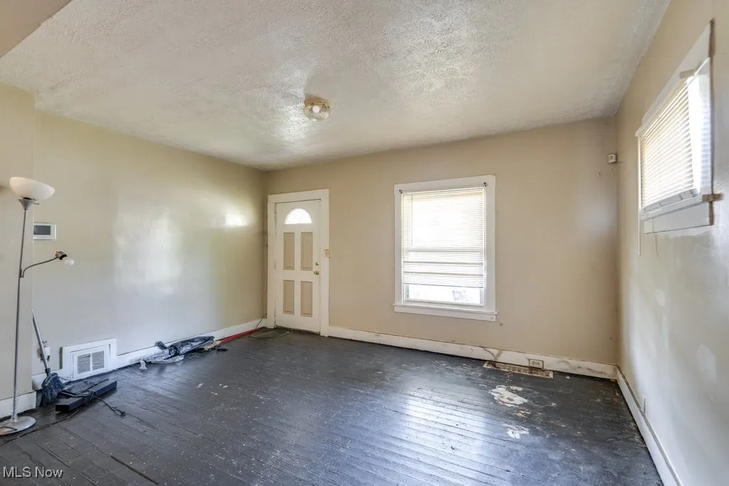 Entrance foyer with a textured ceiling, plenty of natural light, and wood-type flooring