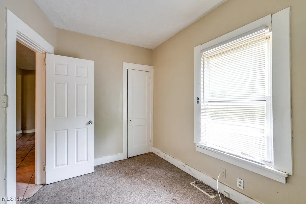 Unfurnished bedroom with baseboards and carpet flooring