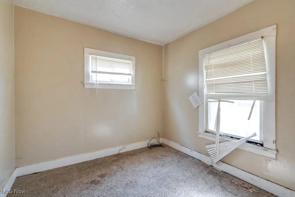 Empty room with carpet flooring and baseboards