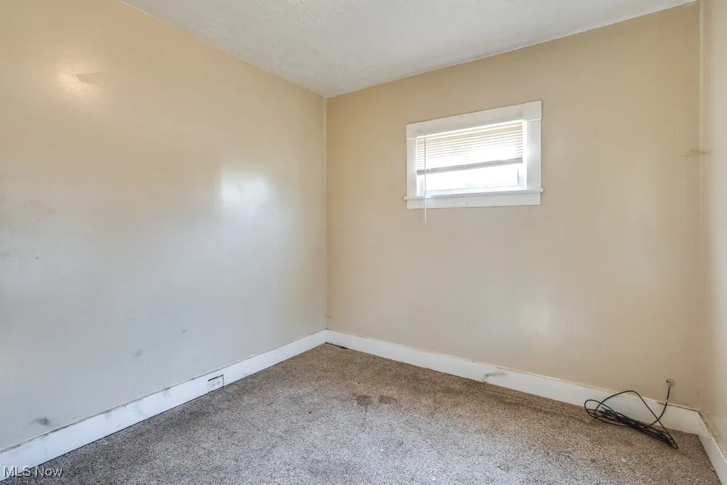 Carpeted spare room with baseboards