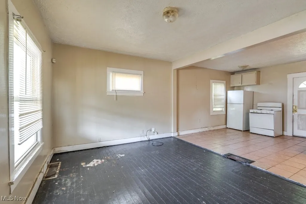 Unfurnished living room with baseboards and a textured ceiling