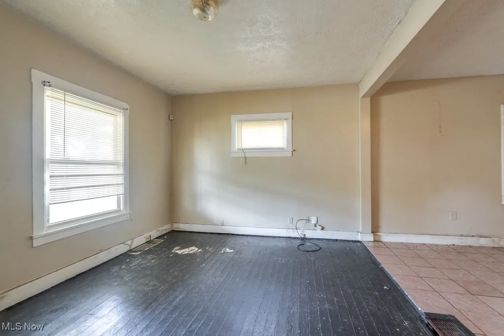 Unfurnished room featuring a textured ceiling and baseboards