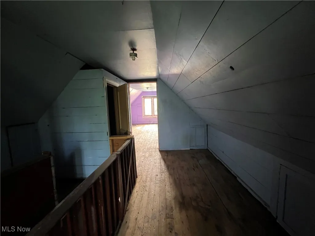 Additional living space with vaulted ceiling and hardwood / wood-style floors