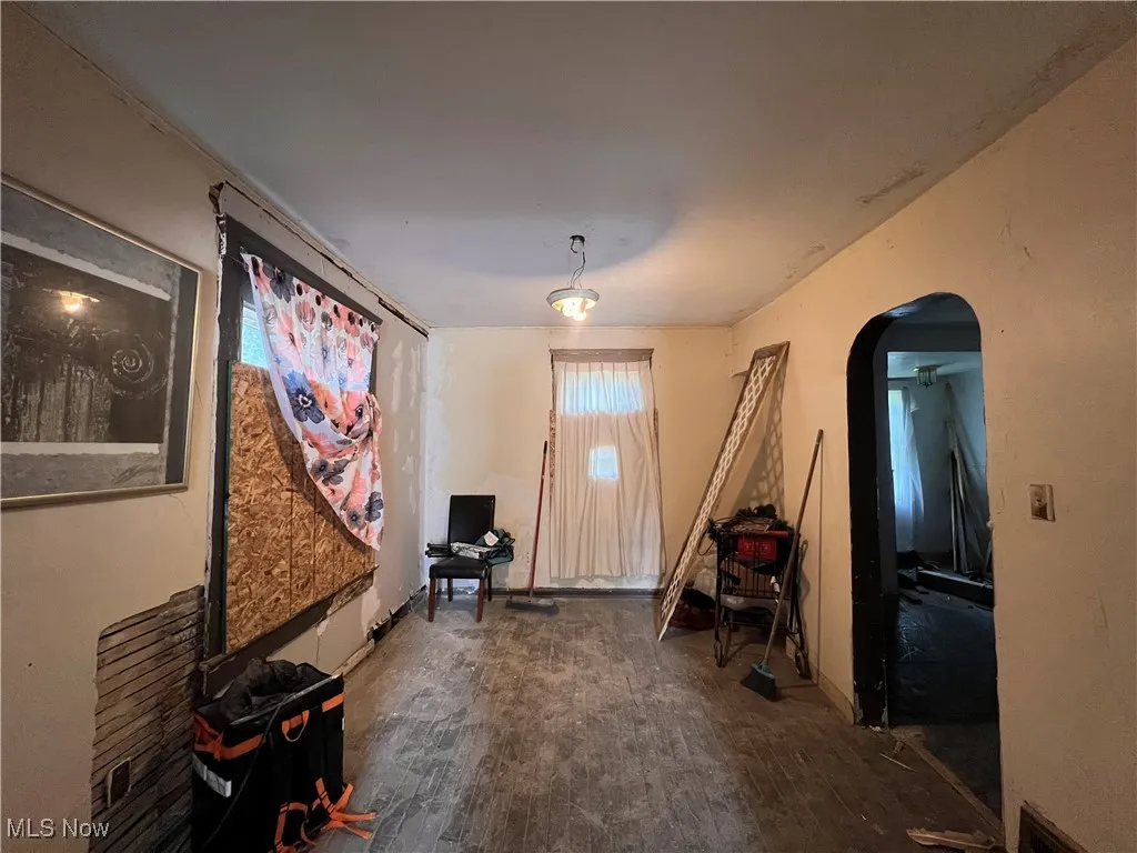 Entryway with arched walkways and wood finished floors